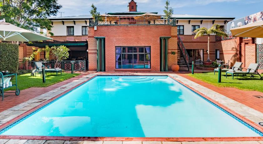 a house with a pool and a pool table in front of it, Courtyard Hotel Rosebank Johannesburg in Johannesburg