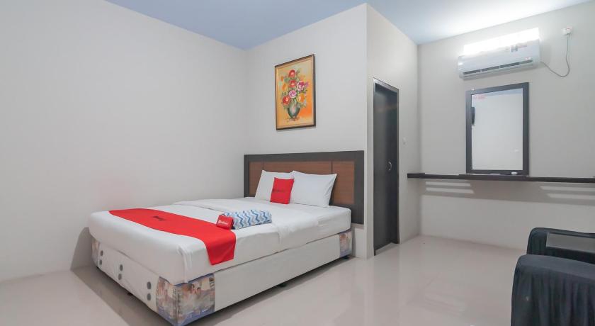 a hotel room with a bed and a desk, RedDoorz Syariah near Stasiun Cianjur in Puncak