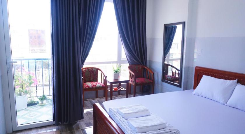 a hotel room with a bed, desk, chair and window, Homestay Bao Tran in Phan Thiet