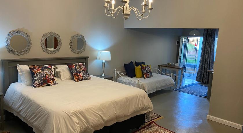 a bedroom with a large bed and a large mirror, Steenkoppies semi self catering apartment in Magaliesburg