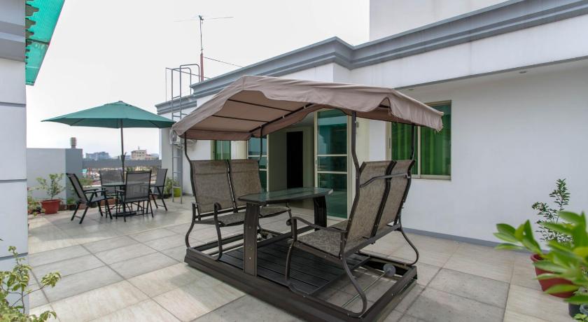 an umbrella sitting on top of a wooden bench, Starlight Bed and Breakfast in Manila