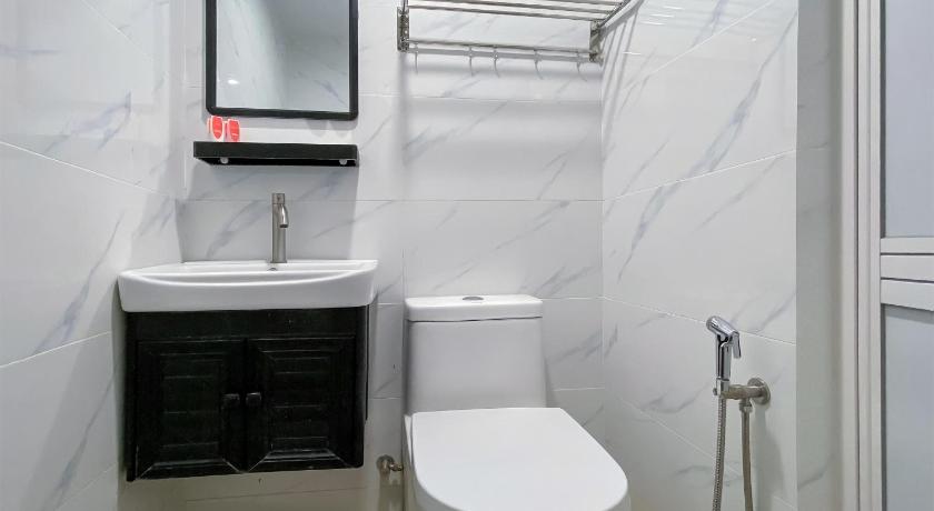 a white toilet sitting next to a white sink, Super OYO 90039 Coop Hotel Kangar in Kangar