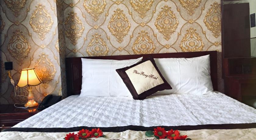 a bed with a white comforter and pillows, Phan Rang Hotel in Phan Rang – Tháp Chàm (Ninh Thuận)