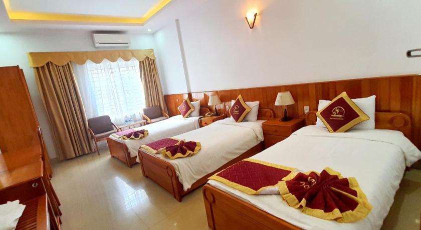 a hotel room with two beds and two tables, Quy Nhon Hotel in Quy Nhon (Binh Dinh)