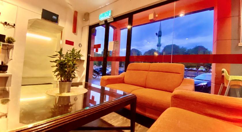 a living room filled with furniture and a tv, Hotel Aman in Nilai
