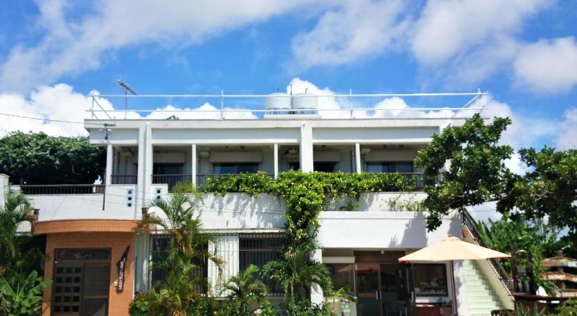 a large white building with a large window, Guest House Shiraho Friends House in Ishigaki