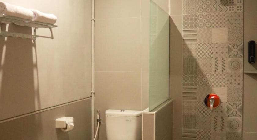 a bathroom with a toilet and a shower stall, D'Carol Hotel in Surabaya