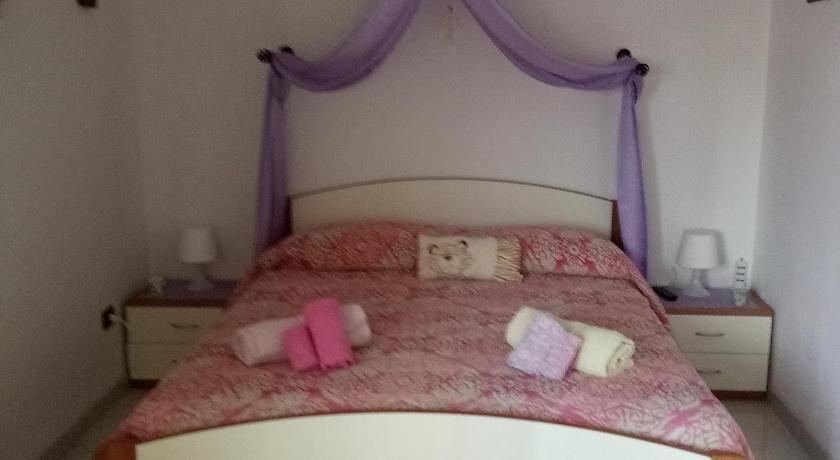 a bed with a pink blanket and pillows on top of it, Rossyiva in Minturno