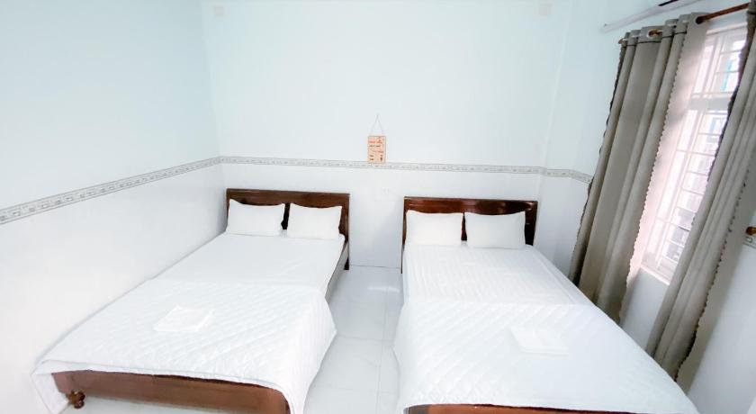 two beds in a room with white walls, An Phat Motel in Quy Nhon (Binh Dinh)