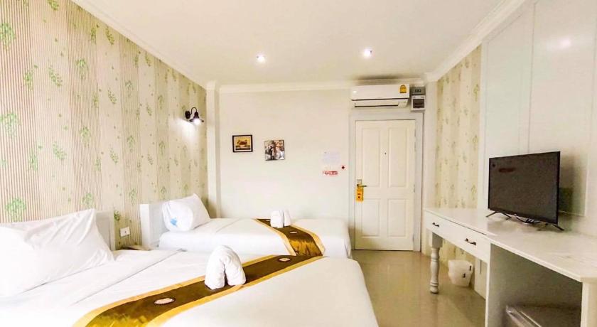 a hotel room with a bed, television and a desk, Ploy's Pearl Hotel in Surat Thani