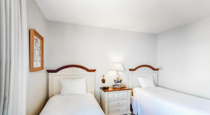 a bedroom with a white bed and white walls, Magnolia House at Destin Pointe III in Destin (FL)