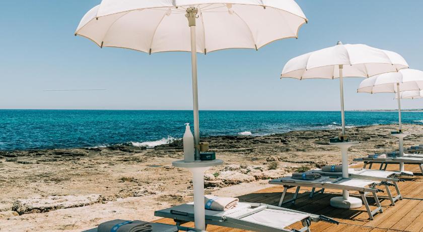 a beach area with chairs, tables and umbrellas, Torre Cintola Natural Sea Emotions in Monopoli