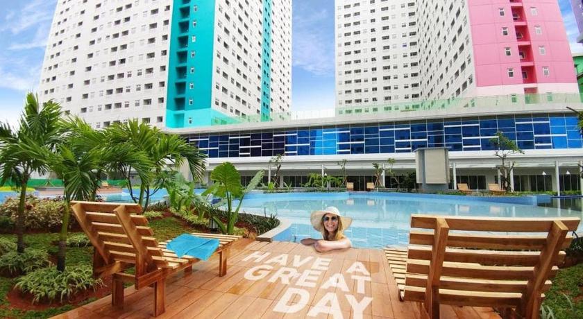 a hotel room with a balcony overlooking the ocean, Properti9 at Apartemen Green Pramuka in Jakarta
