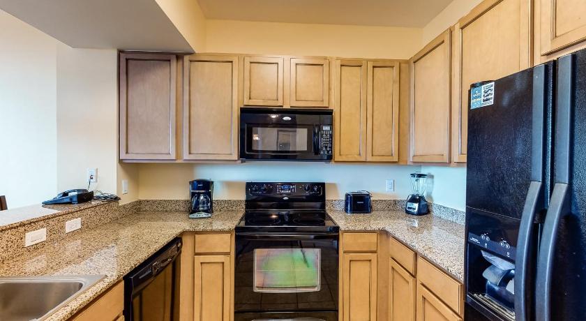 a kitchen with a stove top oven and microwave, The Palms of Destin in Destin (FL)