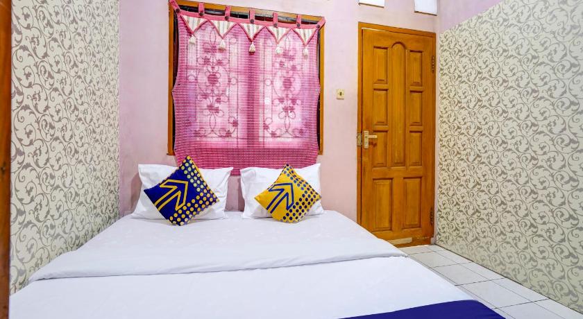 a bedroom with a pink bedspread and a blue bedspread, SPOT ON 90171 Pondok Kuning in Bandung