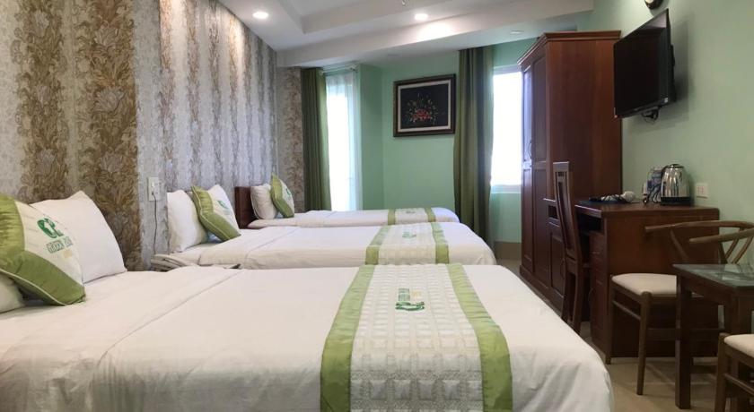 a hotel room with a bed, chair, table and lamps, Green Park Hotel in Quy Nhon (Binh Dinh)