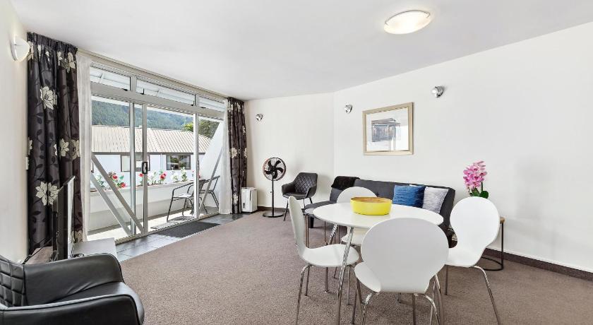 a living room filled with furniture and a table, Amity Serviced Apartments in Queenstown