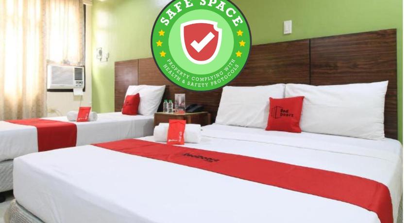 a hotel room with a large bed and a red and white bedspread, RedDoorz Plus @ Chinatown Binondo in Manila