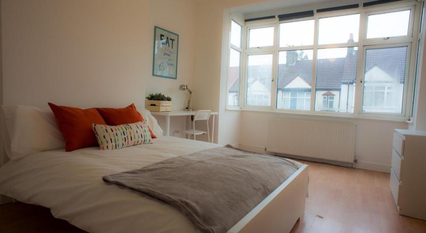 a white bed sitting in a bedroom next to a window, Tooting Bec Rooms at Fishponds by DC London Rooms in London