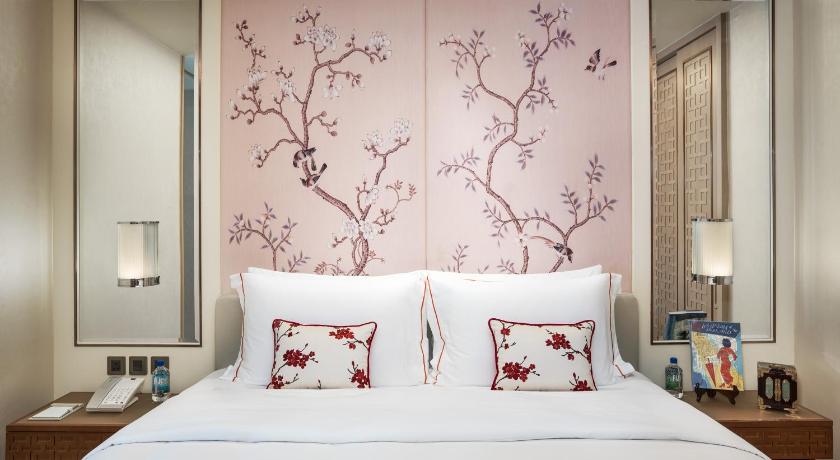 a bedroom with a large bed and a painting on the wall, The Pottinger Hong Kong in Hong Kong