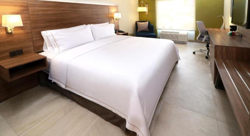 a hotel room with a bed and a desk, Holiday Inn Express & Suites Guadalajara Aeropuerto in Guadalajara