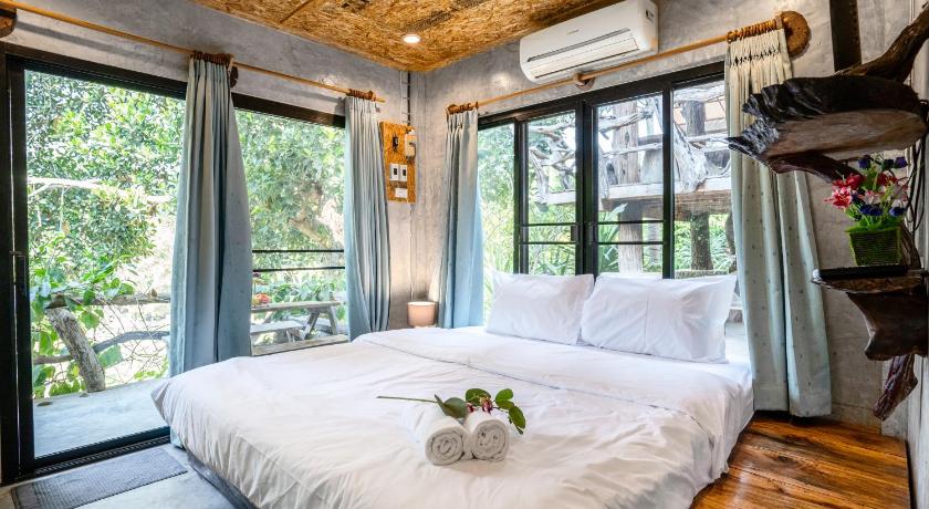 a bedroom with a large bed and a large window, คอร์เดีย 1BR Baan Rai Rim Tarn 会说中文 in Phetchaburi