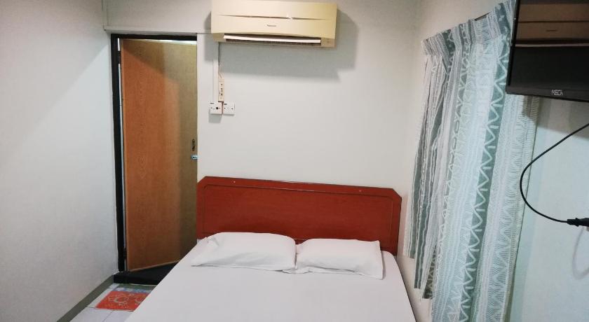 a hotel room with a white bed and white walls, Sri Gate Hotel in Dungun