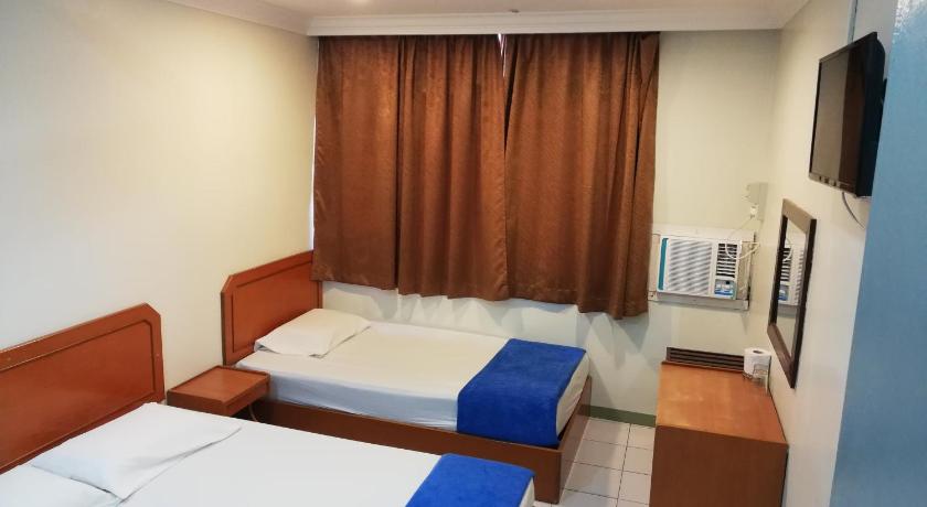 a hotel room with two beds and a television, Sri Gate Hotel in Dungun