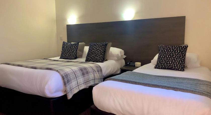 a hotel room with two beds and two nightstands, Fairways Lodge & Leisure Club in Manchester