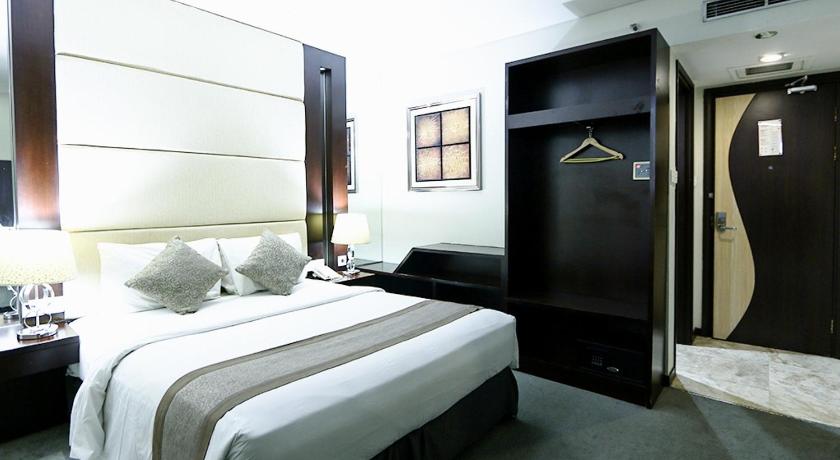 a hotel room with two beds and a television, Serela Waringin Hotel in Bandung