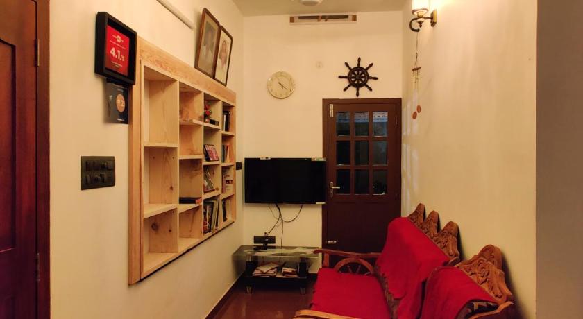 a living room filled with furniture and a fireplace, Calvin's Inn in Kochi