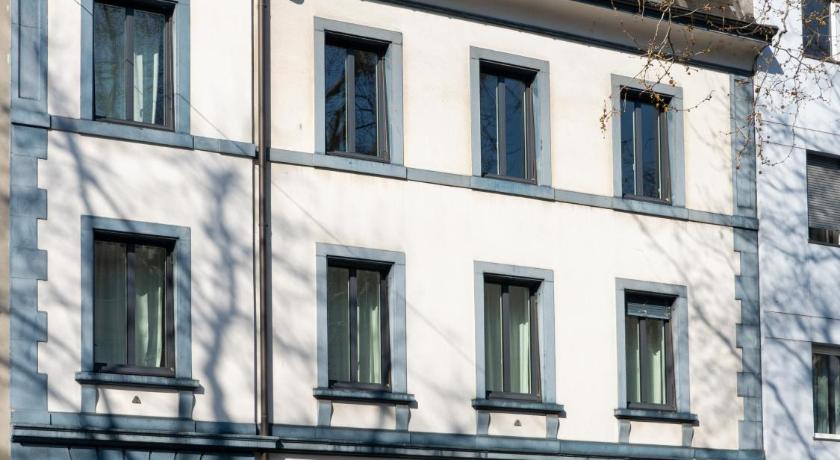 a large white building with a large window, Apartments Spalenring10 in Basel