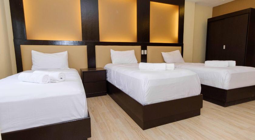 a hotel room with two beds and two lamps, Northpointe Residences in Manila