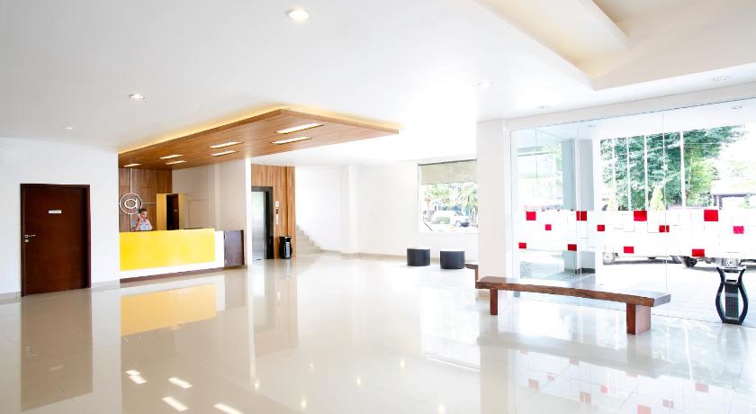 a living room filled with furniture and a large window, Amaris Hotel Muara Bungo - Jambi in Jambi