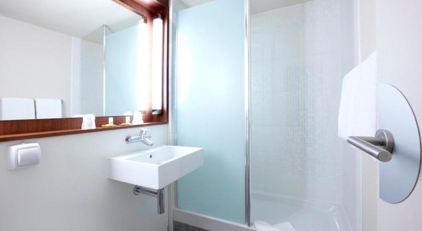 a bathroom with a shower, sink, and mirror, Campanile Roissy in Paris