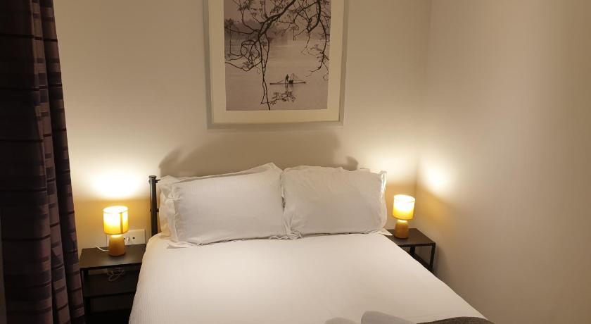 a hotel room with a bed and a lamp, Birmingham Garnet, 3 bedroom Apartment in Birmingham