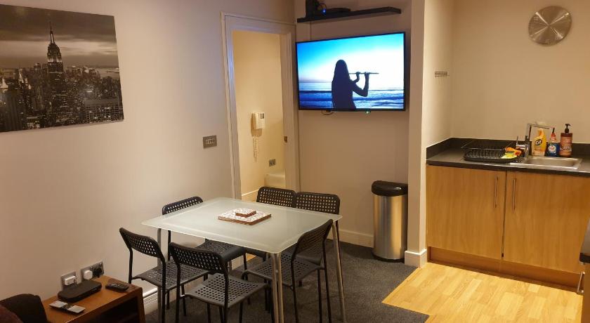 a kitchen with a table and chairs and a television, Birmingham Garnet, 3 bedroom Apartment in Birmingham