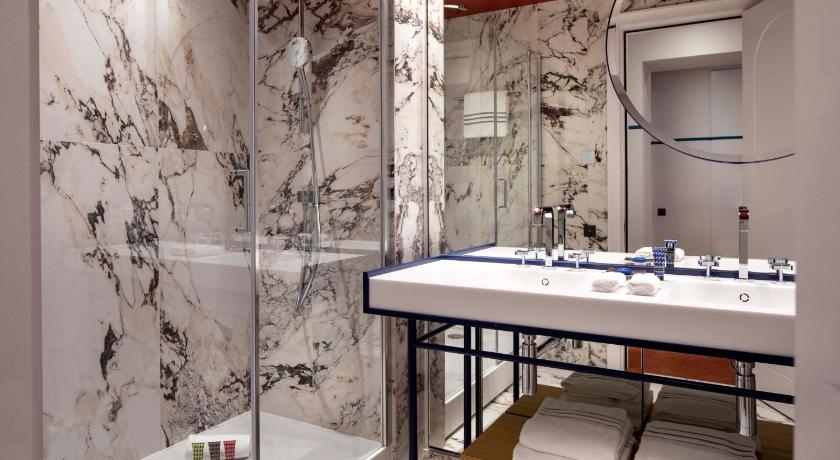 a bathroom with a sink, mirror, and bathtub, Hotel Bel Ami in Paris