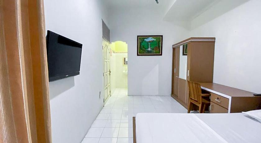 a hotel room with a television and a toilet, Damigalova Guest House RedPartner in Jambi