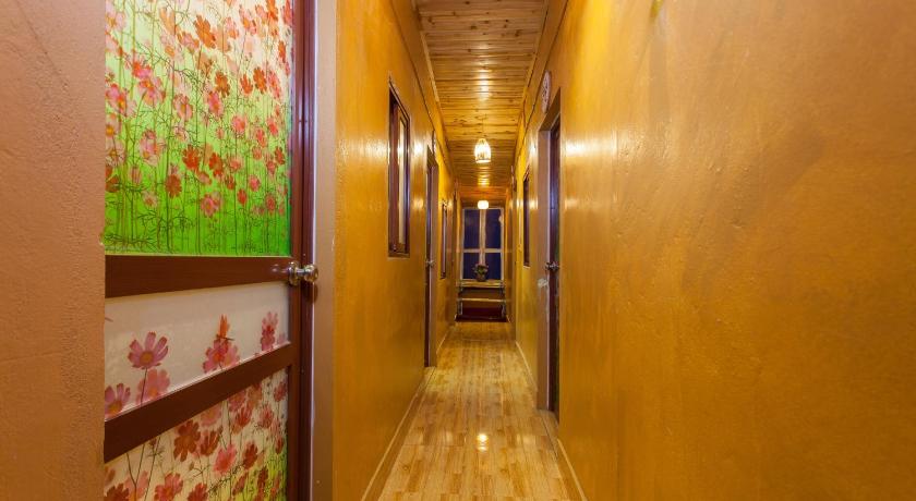 a hallway with a door leading to a hallway with a staircase, Little View Homestay in Sapa