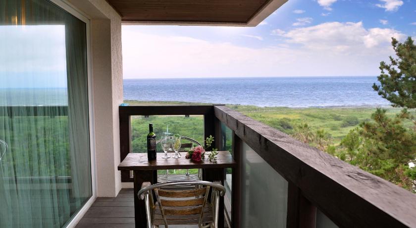 a dining room table with a view of the ocean, Soul Mini Hotel in Jeju