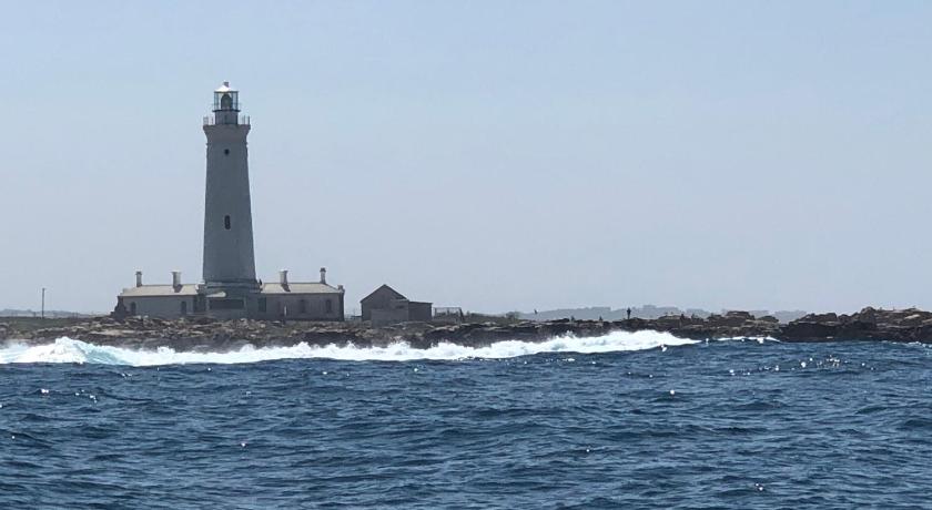 a lighthouse in the middle of a large body of water, Cape St Francis Resort in Cape St. Francis