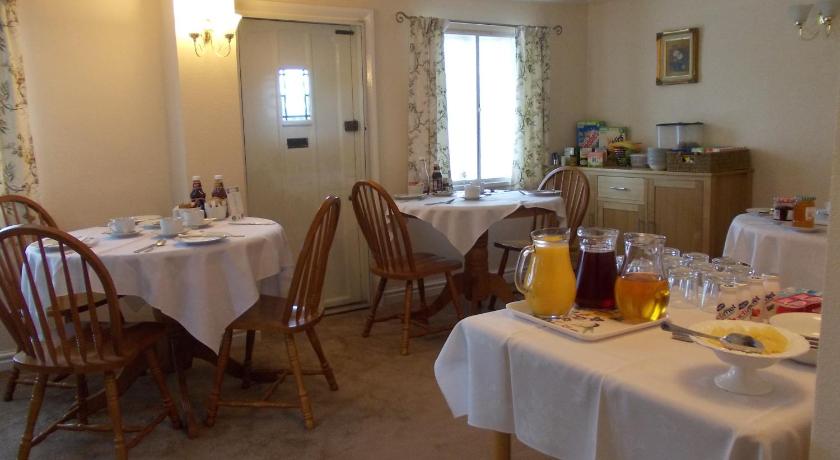 a dining room table with chairs and a table cloth, Rose Cottage Bed & Breakfast in Birmingham