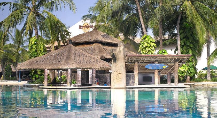 a tropical beach with palm trees and umbrellas, Hard Rock Hotel Bali in Bali