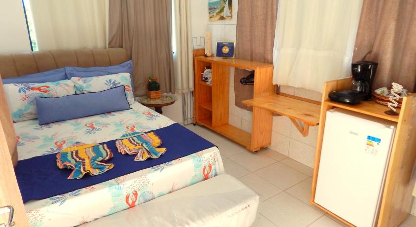 a bedroom with a bed and a desk, Suites Igogaram in Maragogi
