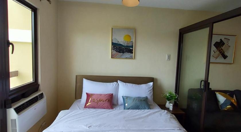 a bedroom with a bed and a lamp on the wall, Lou Condo Rental in Cagayan De Oro