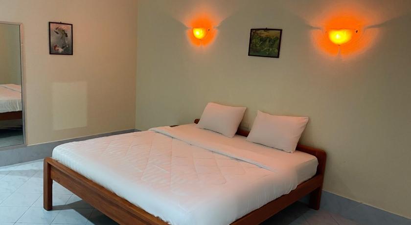 a hotel room with a bed and a lamp, GPM Resort Pattaya in Pattaya