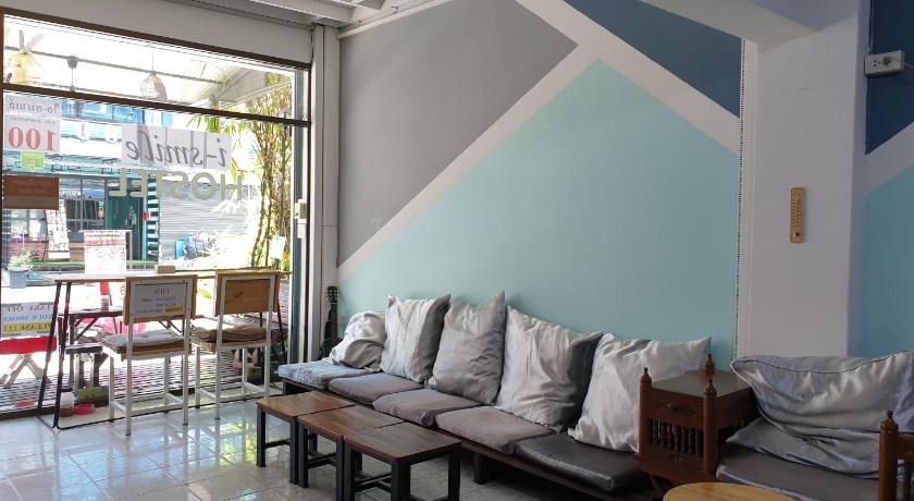 a living room filled with furniture and a large window, i-smile Hostel in Chiang Mai