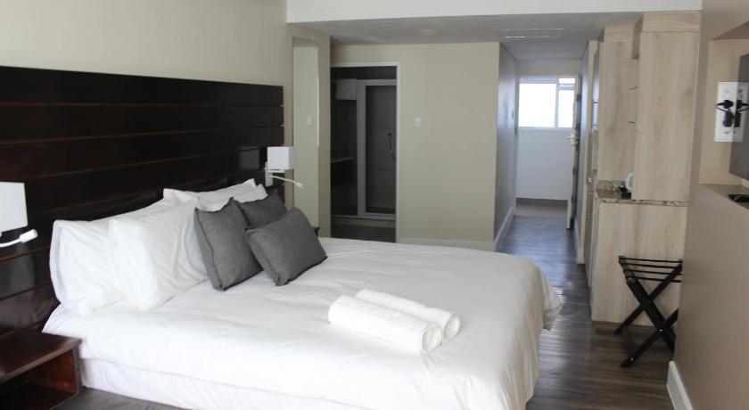 a hotel room with a large bed and a large window, Luxe-Molen Boutique Hotel in Queenstown