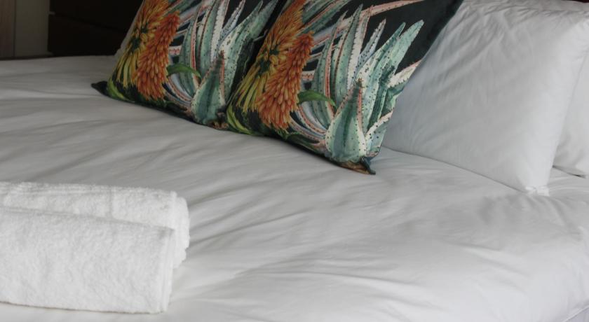 a bed with white pillows and pillows on it, Luxe-Molen Boutique Hotel in Queenstown